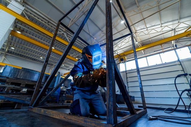 Industrial welder in safety mask working with metal
