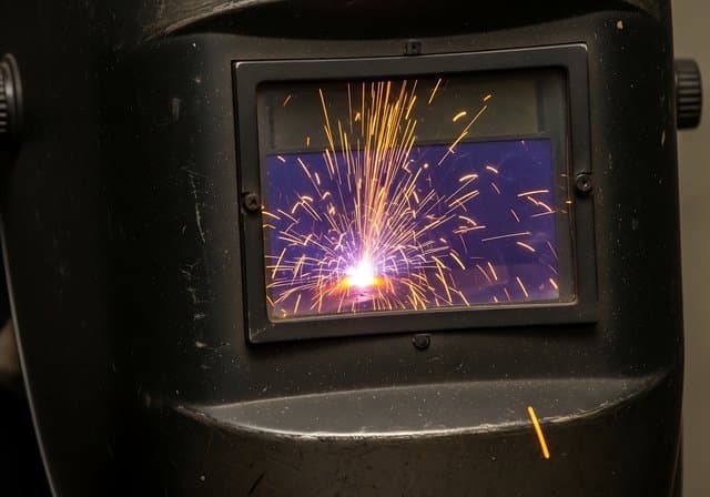 Welding sparks and welding mask close-up